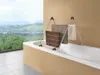 A metal clothes drying rack with towels is placed over a bathtub, with a scenic view of hills and a lake in the background. Voir les images du produit