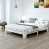 A white wooden bed frame with a white mattress and grey bedding in a bright, minimalist bedroom. Náhled obrázku produktu