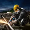 A worker in protective gear is using an angle grinder on a railway track at dusk. Náhľad obrázku produktu