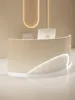 A modern reception desk with a curved design and integrated lighting. Voir les images du produit