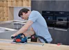 A man is using a circular saw with a guide rail in a kitchen setting. Anteprima dell’immagine prodotto
