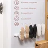 A wall-mounted shoe dryer with several pairs of shoes hanging on it, next to a door and a basket. Produktbild-Vorschau