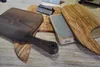 Several wooden cutting boards and a sharpening stone are displayed on a wooden surface. Anteprima dell’immagine prodotto