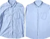 Two light blue button-down shirts are displayed side-by-side. The shirt on the left is wrinkled, while the shirt on the right is neatly pressed. Produktbild-Vorschau
