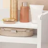 Several cosmetic products and a decorative box are displayed on white shelves. Anteprima dell’immagine prodotto