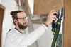 A man is using a sander on a wall. Voir les images du produit