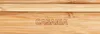 Close-up of a bamboo surface with the brand name engraved. Produktbild-Vorschau
