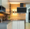A modern kitchen with a black glass range hood mounted on a wood-paneled wall. Produktbild-Vorschau