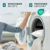 A person is putting a pillow into a washing machine. Produktbild-Vorschau