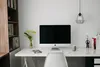 A clean and modern home office setup with a computer, desk, chair, and bookshelf. Produktbild-Vorschau