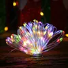 A close-up of colorful LED string lights arranged in a flower-like shape on a wooden surface. Produktbild-Vorschau