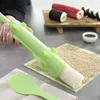 A person is using a sushi-making tool to roll rice, with finished sushi rolls in the background. Voir les images du produit