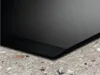 Close-up of a black induction cooktop resting on a speckled countertop. Podgląd zdjęcia produktu