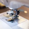 A close-up view of the needle and presser foot of a sewing machine. Produktbild-Vorschau