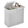A grey laundry basket with two compartments and a wooden lid, with two bottles on top. Produktbild-Vorschau