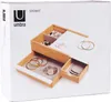 A product shot of a wooden jewelry box with multiple compartments and drawers, displaying various jewelry items. Voir les images du produit
