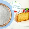 A bowl of white granular sweetener next to a slice of cake topped with berries and powdered sugar. Produktbild-Vorschau