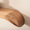 A close-up view of a wooden shelf mounted on a wall. Voir les images du produit