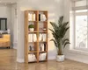 A modern wooden bookshelf filled with books and decorative items, placed in a bright living room next to a large window and a potted plant. Produktbild-Vorschau
