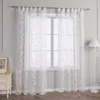 A pair of white sheer curtains with a damask pattern hanging on a window. Produktbild-Vorschau