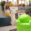 A young girl is playing with her dog in a living room, with a frog-shaped children's chair in the foreground. Produktbild-Vorschau