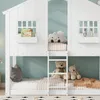 A white bunk bed shaped like a house with windows and a ladder, decorated with stuffed animals and a book. Náhled obrázku produktu