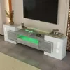 A modern TV stand with a gray concrete-effect finish and glossy white accents, featuring a glass top shelf with integrated green LED lighting. Náhled obrázku produktu