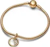A gold-colored Pandora charm bracelet with a circular charm featuring cubic zirconia stones and the letter 'V'. The bracelet has a snake chain design and a spherical clasp with the Pandora logo. Podgląd zdjęcia produktu
