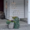 Decorative sphere lights on a porch with plants. Produktbild-Vorschau
