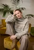 A woman sits on a yellow chair in a room with plants and furniture. Produktbild-Vorschau