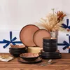Das Geschirrset steht auf dem Tisch, umgeben von Geschenkboxen mit blauen Bändern, und Blumen. Voir les images du produit