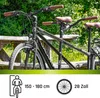 A tandem bicycle parked next to a wooden picnic table with greenery in the background. Produktbild-Vorschau
