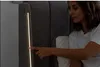 A woman is touching a light strip on the side of a bed. Produktbild-Vorschau