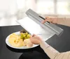 A person is using a foil dispenser to cover food on a plate. Produktbild-Vorschau