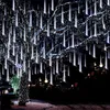 A tree decorated with white icicle lights at night, with a smaller decorated tree in the foreground. Náhled obrázku produktu