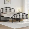 A black metal bed frame with a crown motif headboard is shown in a bedroom setting. Podgląd zdjęcia produktu