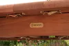 Close-up of the underside of a wooden table with metal latches and a brand logo. Produktbild-Vorschau