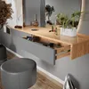 A vanity table with an open drawer, makeup, and a stool in a room. Anteprima dell’immagine prodotto