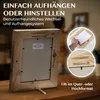 A wooden picture frame is shown on a wooden table, with inset images demonstrating how to insert a picture and how the hanging mechanism works. Text overlays describe the product's features. Produktbild-Vorschau