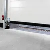 Close-up view of the bottom edge of a white garage door and the concrete floor. Produktbild-Vorschau
