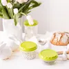 A still life arrangement with food storage containers, tulips, and decorative bunnies. Náhľad obrázku produktu