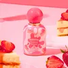 A bottle of Tubbees Strawberry Cheesecake Eau de Parfum is displayed with slices of cheesecake and strawberries. Podgląd zdjęcia produktu