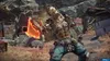 A character from the video game Borderlands 4 is shown in a combat stance, holding a flaming axe. The background is a post-apocalyptic, rocky environment with debris and structures. Produktbild-Vorschau