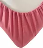 A close-up view of the corner of a pink fitted sheet with elastic gathering. Produktbild-Vorschau
