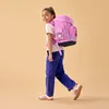 A young girl walking with a pink backpack. Produktbild-Vorschau