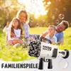Weiß-schwarze Rocket Boom Blasenpistole mit vielen Blasen, eine Familie spielt in einem sonnigen Park Náhľad obrázku produktu