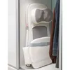 A massage mat is stored upright in a closet next to some clothes. Produktbild-Vorschau