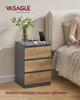 A bedside table with a phone charging on it, next to a bed where a person is sitting. Produktbild-Vorschau