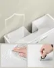 Collage of images showing details of a white bathroom cabinet, including a shield icon, a hand cleaning a wet surface, and a hand scratching the surface with a key. Produktbild-Vorschau