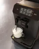 A close-up shot of a black Philips espresso machine dispensing milk into a glass cup. Voir les images du produit